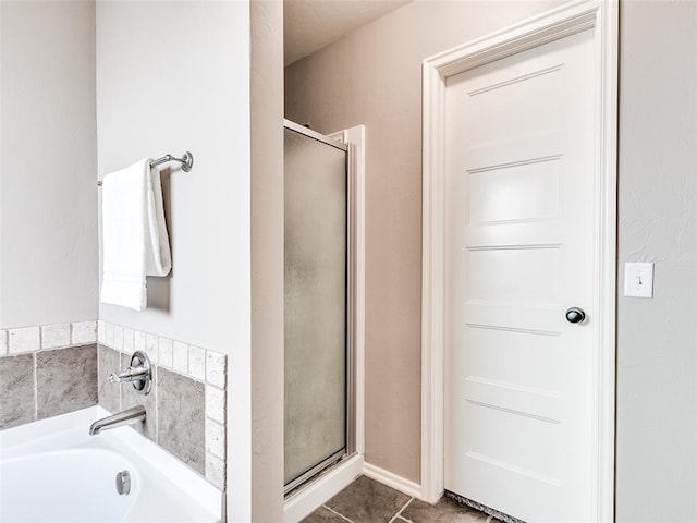 full bathroom with a garden tub, a shower stall, and tile patterned floors