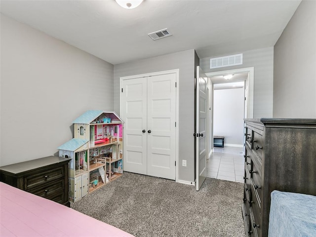 bedroom featuring light carpet, baseboards, visible vents, and a closet