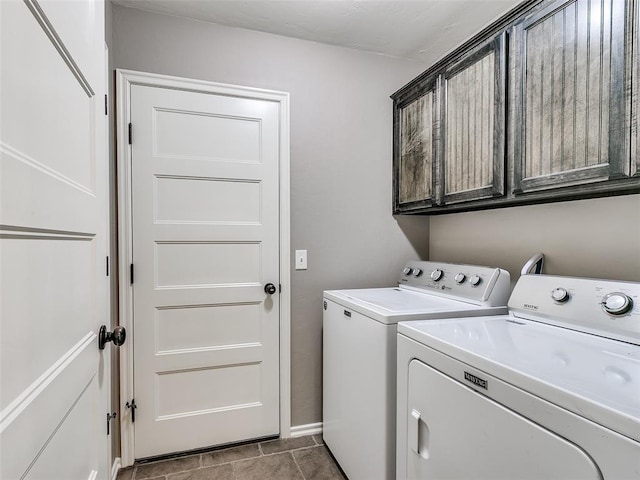 clothes washing area featuring washing machine and dryer, tile patterned flooring, cabinet space, and baseboards