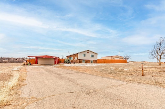 view of front of home with dirt driveway and a garage