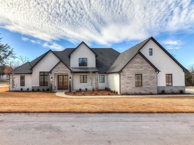 view of front of home featuring stone siding, a standing seam roof, metal roof, and stucco siding