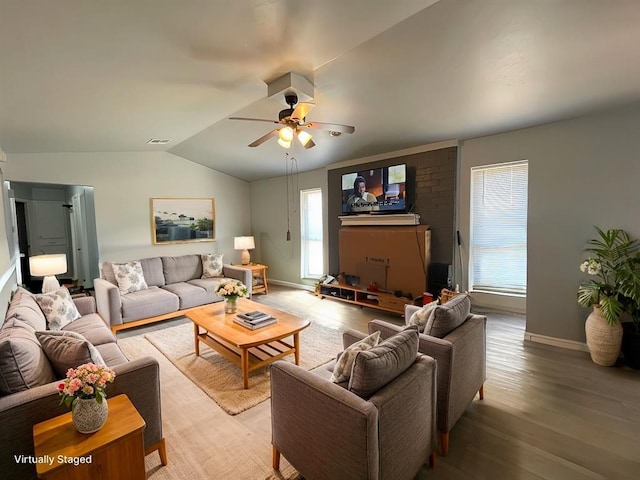 living area featuring lofted ceiling, visible vents, a healthy amount of sunlight, and light wood-style flooring