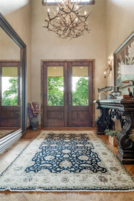 foyer featuring a healthy amount of sunlight, a towering ceiling, and french doors