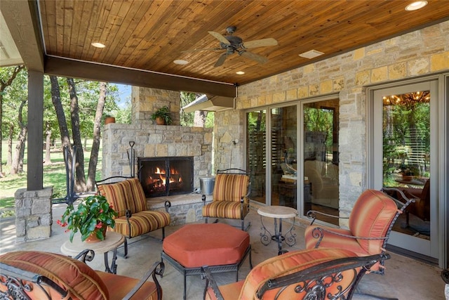 view of patio / terrace featuring an outdoor stone fireplace and a ceiling fan