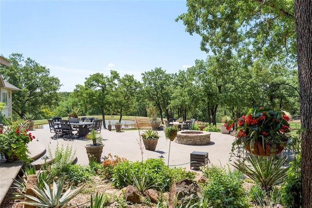 view of property's community featuring an outdoor fire pit and a patio area