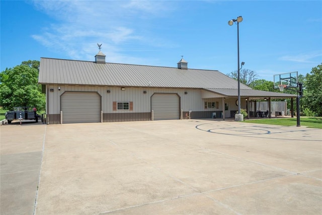 view of front of property featuring a garage, driveway, and metal roof