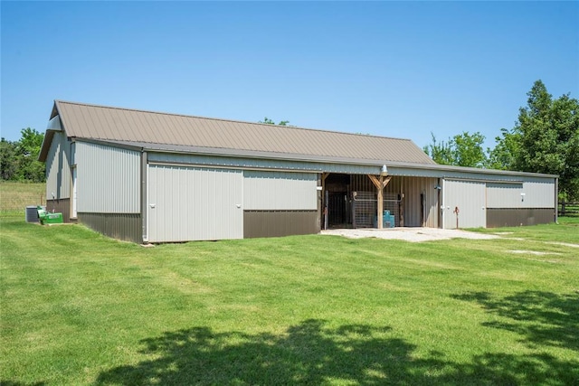 back of property featuring a yard, an outbuilding, metal roof, and an outdoor structure