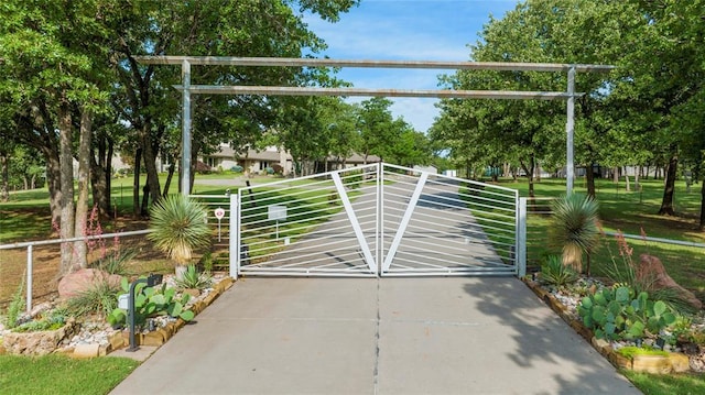 view of gate with a lawn