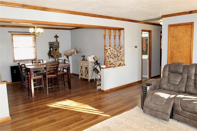 living area featuring a notable chandelier, dark wood-type flooring, ornamental molding, and baseboards