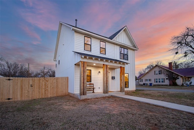 view of front facade with fence, a porch, and board and batten siding