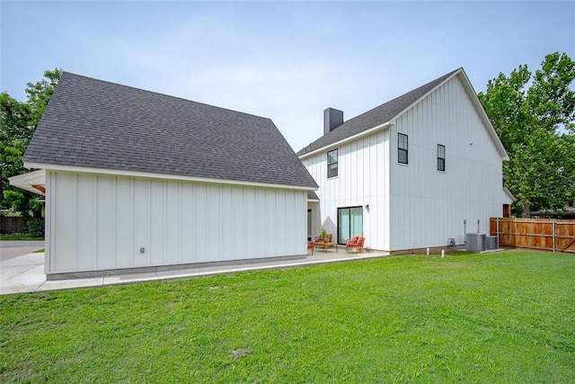 1027 S 7th St, Chickasha, OK 73018 - rear view of house with board and batten siding, a chimney, central AC unit, a patio, and a shingled roof