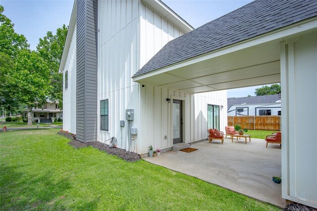 1027 S 7th St, Chickasha, OK 73018 - rear view of property with board and batten siding, a patio, and roof with shingles