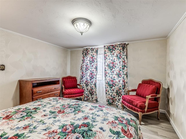 bedroom featuring ornamental molding, baseboards, light wood-style flooring, and a textured ceiling