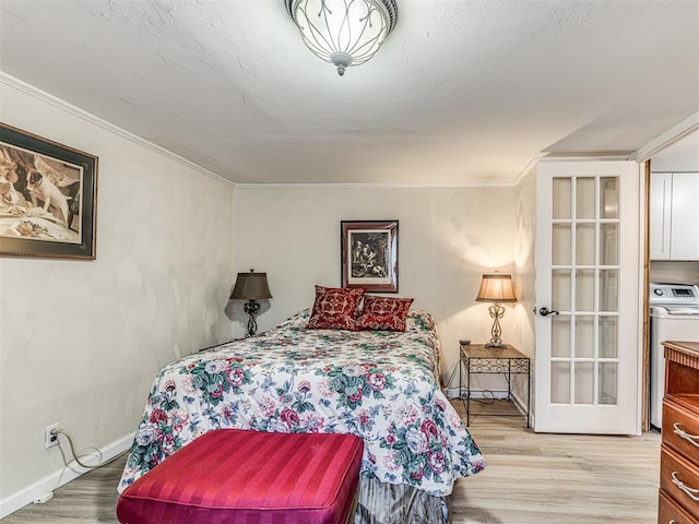 bedroom featuring ornamental molding, light wood-type flooring, washer / dryer, and baseboards