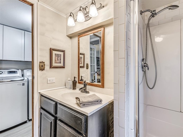 full bathroom with wood finished floors, vanity, independent washer and dryer, a shower stall, and crown molding