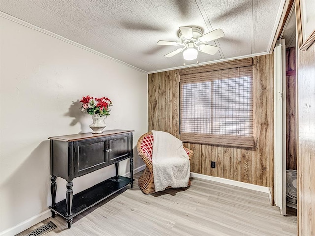 living area featuring ceiling fan, wooden walls, visible vents, and light wood-style floors