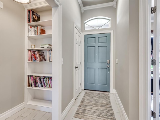 entrance foyer with baseboards and crown molding