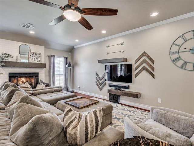 living room featuring baseboards, visible vents, a ceiling fan, ornamental molding, and a brick fireplace