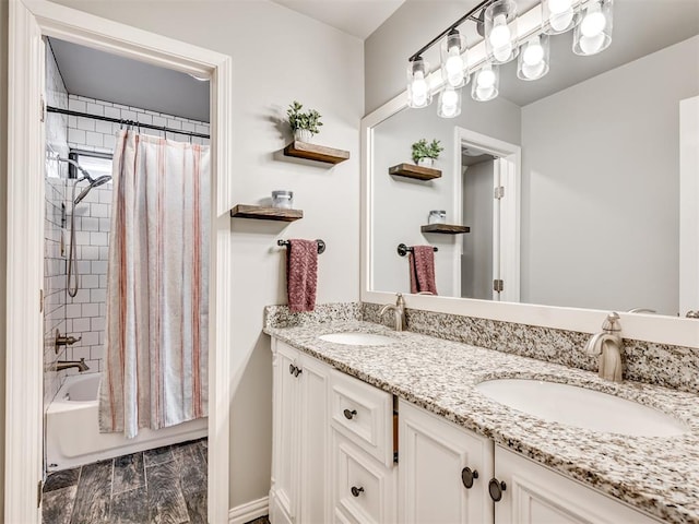 full bath with double vanity, a sink, and shower / bath combo with shower curtain