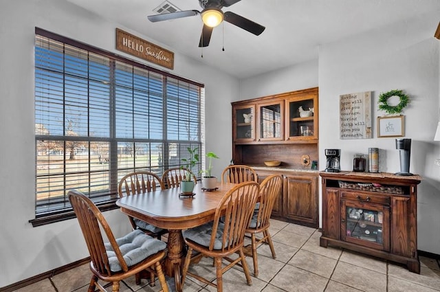 dining area featuring visible vents, ceiling fan, baseboards, and light tile patterned floors