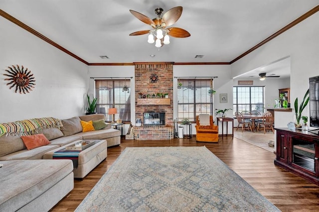 living room with dark wood-style floors, a fireplace, visible vents, and ornamental molding