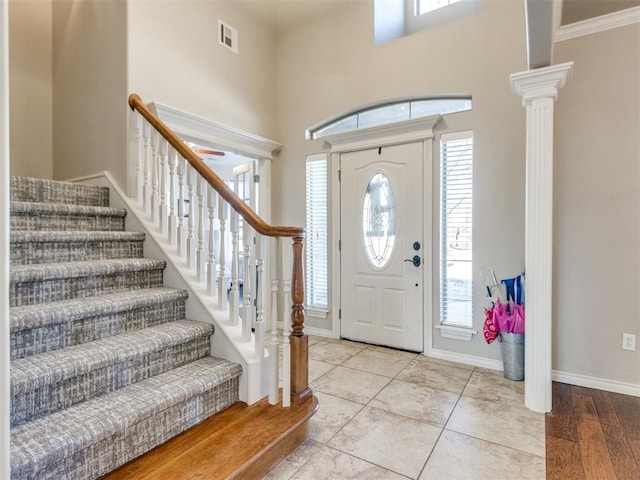 foyer with a wealth of natural light, decorative columns, visible vents, and baseboards