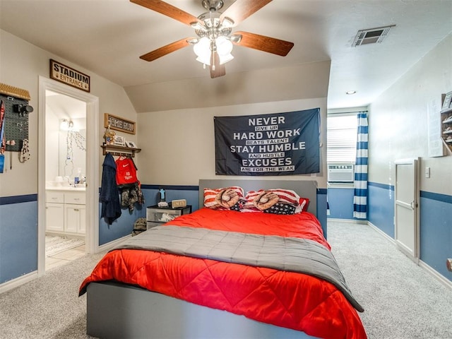 bedroom with connected bathroom, carpet flooring, visible vents, baseboards, and vaulted ceiling