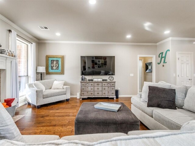 living room featuring recessed lighting, wood finished floors, visible vents, baseboards, and ornamental molding