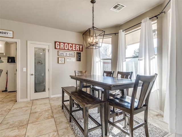 dining area with an inviting chandelier, visible vents, baseboards, and light tile patterned floors