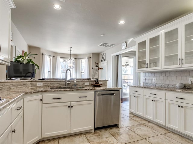 kitchen featuring stainless steel dishwasher, a sink, glass insert cabinets, and white cabinets