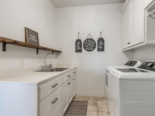 laundry area with cabinet space, baseboards, washer and dryer, and a sink