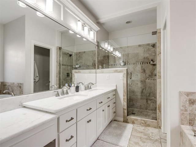 bathroom featuring double vanity, a sink, and a shower stall