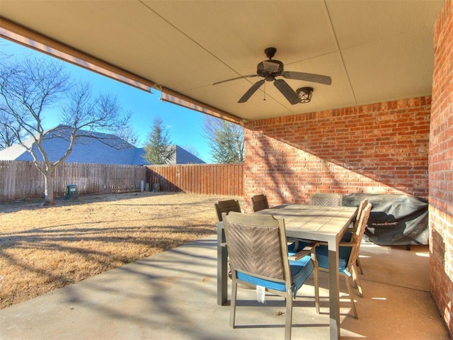 view of patio with outdoor dining area, a fenced backyard, and a ceiling fan