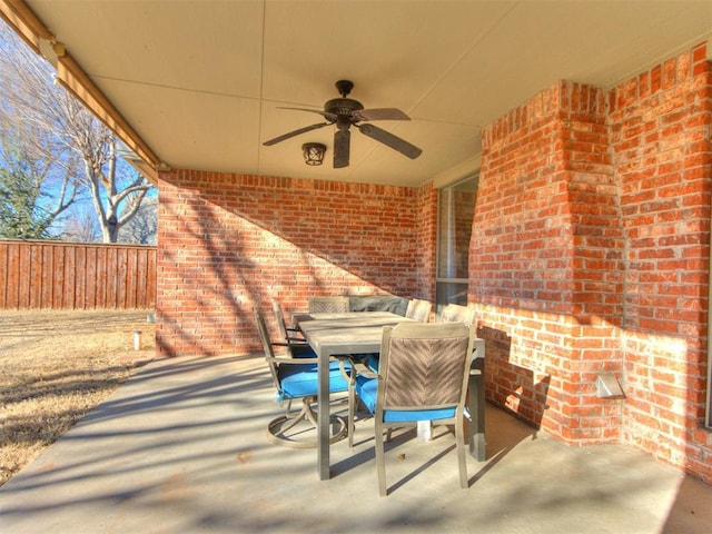 view of patio featuring outdoor dining space, fence, and a ceiling fan