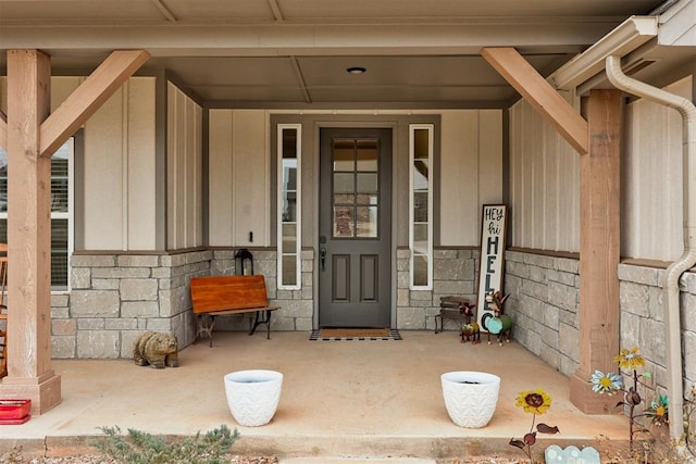 entrance to property featuring stone siding and covered porch