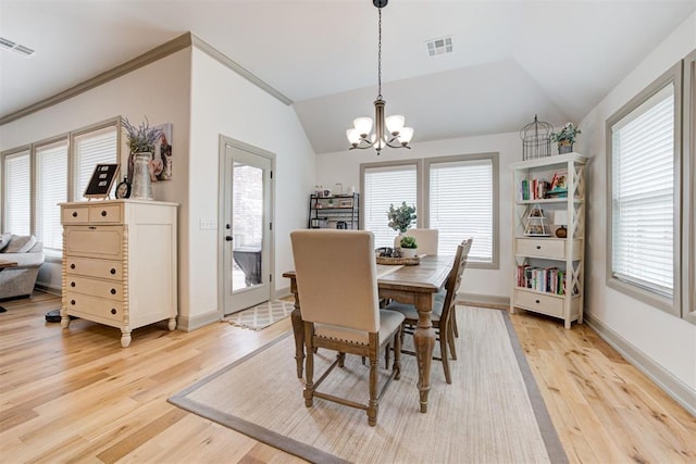 dining area featuring a healthy amount of sunlight, visible vents, vaulted ceiling, and a notable chandelier