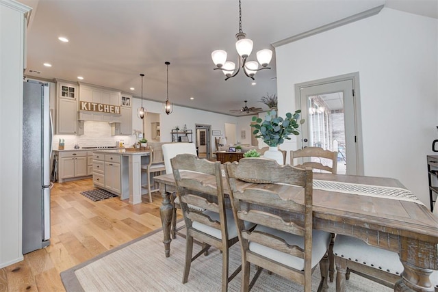 dining area with light wood-style floors, recessed lighting, and ceiling fan with notable chandelier