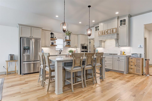 kitchen featuring a center island, pendant lighting, open shelves, appliances with stainless steel finishes, and light stone countertops