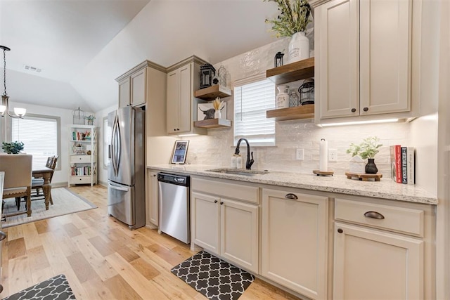 kitchen featuring open shelves, stainless steel appliances, lofted ceiling, light wood-style floors, and a sink