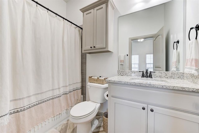 full bath featuring a shower with curtain, vanity, and toilet