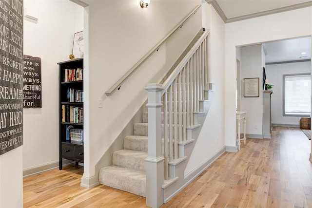 stairs featuring ornamental molding, wood finished floors, and baseboards