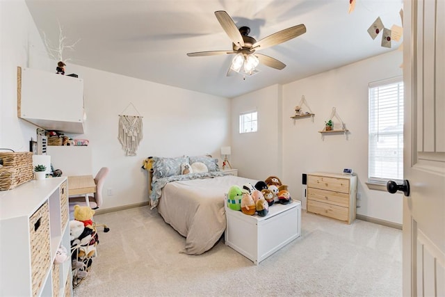 bedroom featuring light carpet, baseboards, and a ceiling fan