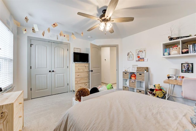 bedroom with a closet, a ceiling fan, and light colored carpet