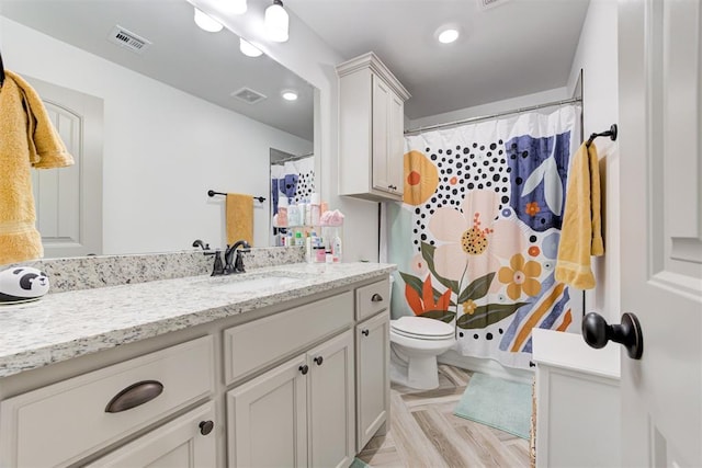 bathroom with a shower with curtain, visible vents, vanity, and toilet