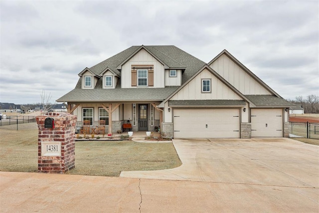 view of front of home featuring driveway, stone siding, fence, a shingled roof, and covered porch