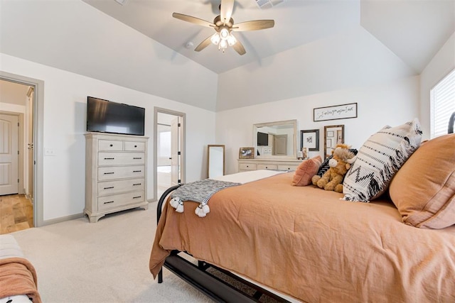 bedroom with baseboards, a ceiling fan, ensuite bath, vaulted ceiling, and light colored carpet