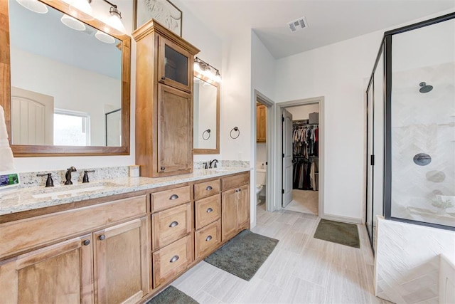 bathroom with a sink, visible vents, a shower stall, and double vanity