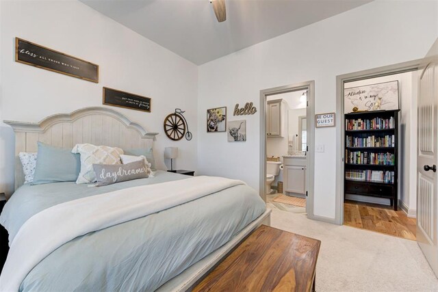 bedroom featuring ceiling fan, ensuite bath, light carpet, and baseboards