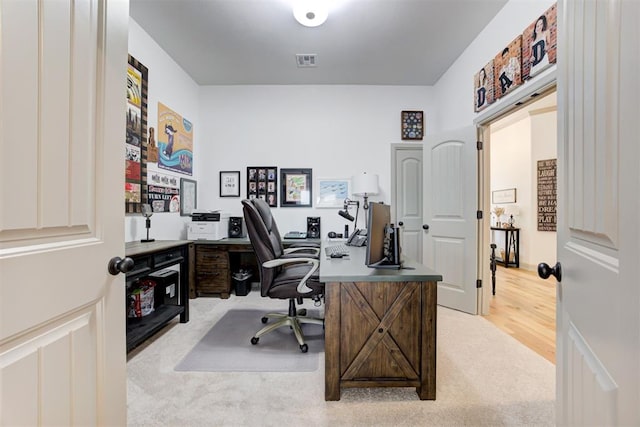 office area featuring visible vents and light carpet