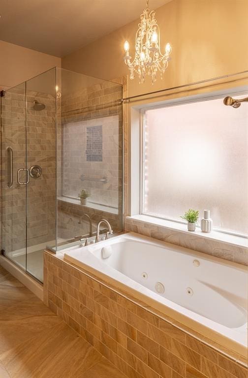 full bathroom featuring a jetted tub, a stall shower, and a chandelier